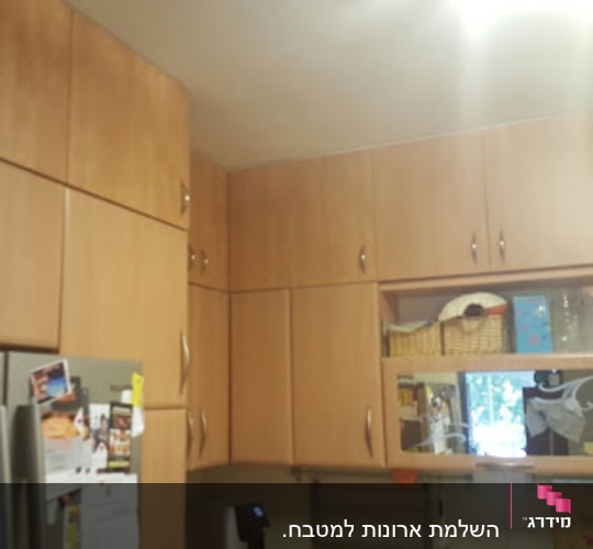 מטבח עם ארונות עץ ומקרר